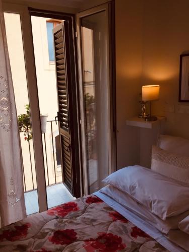 a bedroom with a bed and a door to a balcony at Casa tipica siciliana patronale home BedandBreakfast TreMetriSoprailCielo Camere con vista, colazione interna in terrazzo panoramico in Caltagirone