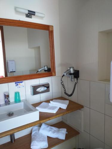 une salle de bain avec un lavabo et un miroir dans l'établissement Les Rochers, à Carnac