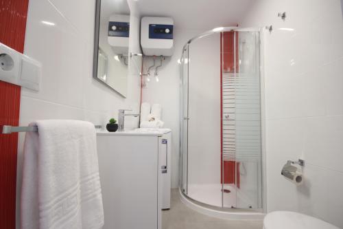 a white bathroom with a shower and a sink at Apartment with terrace in Playa de Las Americas in Playa de las Americas
