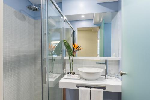 a bathroom with a sink and a glass shower at Pestana Churchill Bay in Câmara de Lobos