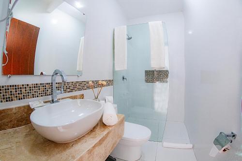 a bathroom with a sink and a toilet and a shower at Pousada Natureza in Morro de São Paulo