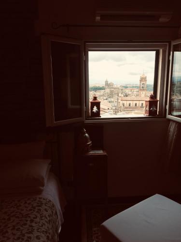 a bedroom with a window with a view of a city at Casa tipica siciliana patronale home BedandBreakfast TreMetriSoprailCielo Camere con vista, colazione interna in terrazzo panoramico in Caltagirone