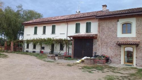 a white house with green shutters on it at Agriturismo Cascina Poscallone in Abbiategrasso