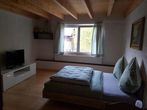a bedroom with a bed and a window at Bio Hof Moosburg am See mit Sauna in Güttingen
