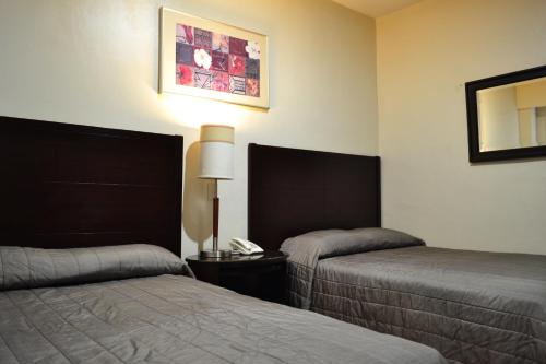 En eller flere senge i et værelse på Hotel America Palacio