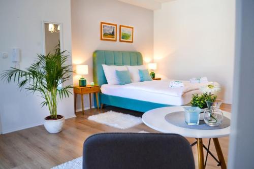 Un dormitorio con una cama y una mesa con una planta en Happy Studio Apartment, en Mostar