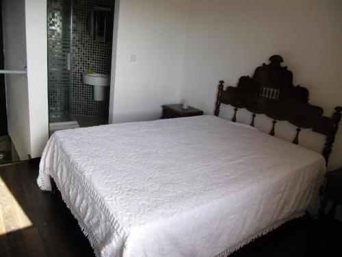a bedroom with a large bed with a white bedspread at Casas de Campo Podence in Macedo de Cavaleiros