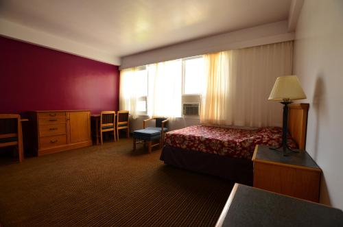 a hotel room with a bed and a window at Hotel Royal Plaza in Winnipeg