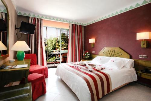 une chambre d'hôtel avec un lit et un fauteuil rouge dans l'établissement Chems Hotel, à Marrakech