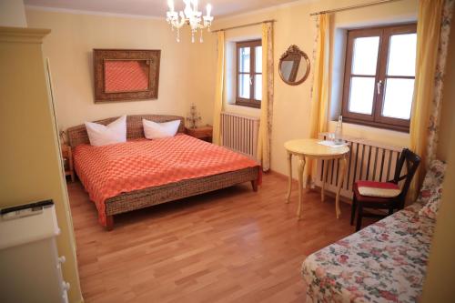 1 dormitorio con 1 cama, 1 mesa y 1 silla en Seewirt Ecking, en Riedering