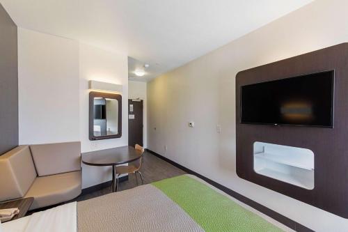 a room with a bed and a table and a tv at Motel 6 Austin Airport in Austin