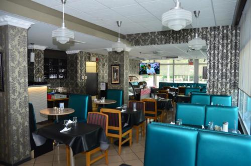 a dining room with blue chairs and tables at Hotel Royal Plaza in Winnipeg