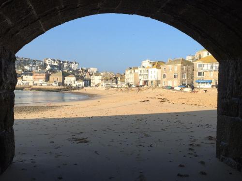 een uitzicht op een strand vanaf een stenen boog bij Talland Studio in St Ives