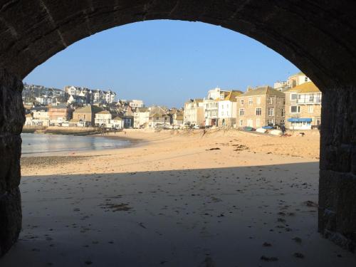 - Vistas a la playa desde un arco de piedra en Talland Studio, en St Ives