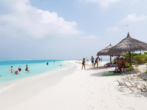 a group of people on a beach with the ocean at Sea View Villa Ukulhas in Ukulhas