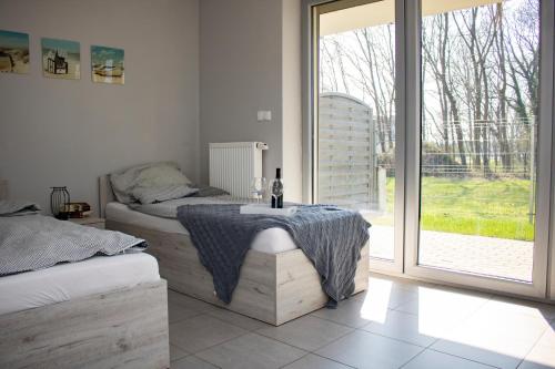 Un dormitorio con una mesa con una botella de vino. en Villa Klif, en Rewal