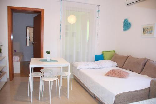 a living room with a couch and a table and chairs at Babe beach Apartment in Novalja