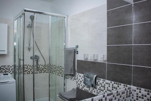 Un baño con ducha con puerta de cristal en Villa Klif, en Rewal