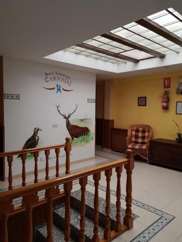 a lobby with a large poster of a deer and a bird at Hotel Carvajal in Torrejón el Rubio