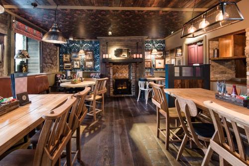 a restaurant with wooden tables and chairs and a fireplace at The Seaton Lane Inn - The Inn Collection Group in Seaham