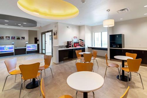 a waiting room with tables and chairs and a tv at Motel 6 Austin Airport in Austin
