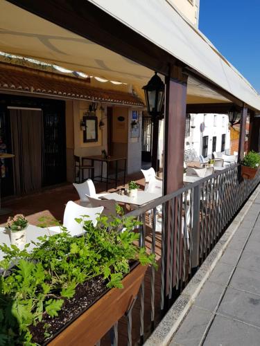 a restaurant with tables and chairs on a patio at Hotel Carvajal in Torrejón el Rubio