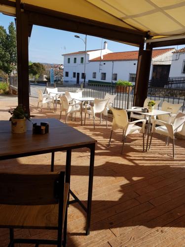 
a dining room table with chairs and umbrellas at Hotel Carvajal in Torrejón el Rubio
