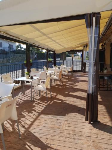 a row of tables and chairs under a canopy on a patio at Hotel Carvajal in Torrejón el Rubio