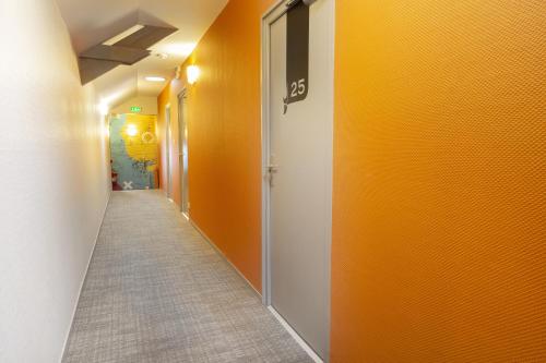 a corridor of a hallway with orange walls at Logis Hôtel Chaptal, Amboise in Amboise