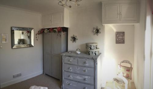 a room with a blue dresser and a mirror at Beautiful Character Property in Angmering