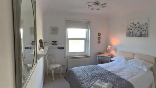 a bedroom with a bed and a window and a mirror at Beautiful Character Property in Angmering