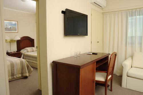 a hotel room with a desk and a tv at Hotel Sunset Beach in Punta del Este