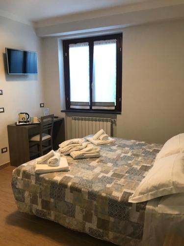 a bedroom with a bed with a desk and a window at Antiche Terre Hotel & Relax in Pignone