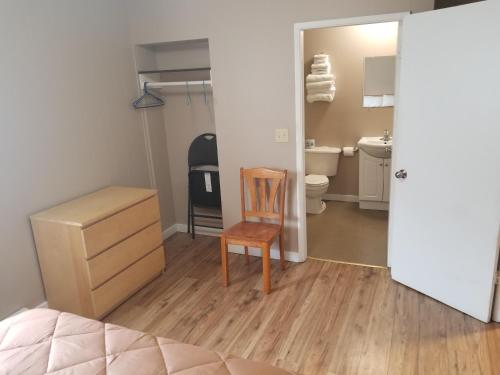 a bedroom with a desk and a chair and a bathroom at Apple Tree Inn in Penticton