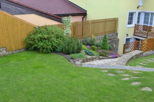 a garden in front of a house with a fence at Privat Julia in Vrbov