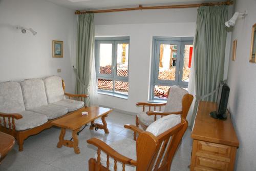 sala de estar con sofá, sillas y mesa en Apartamentos San Sebastián en San Sebastián de la Gomera