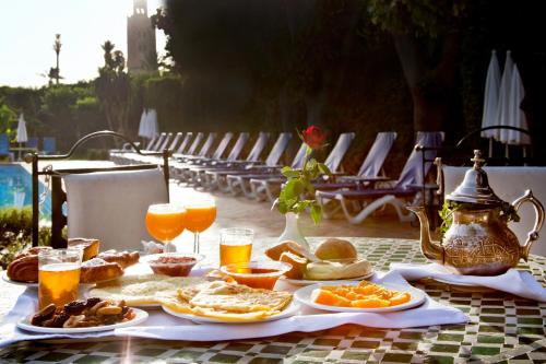 a table with plates of food and glasses of orange juice at Chems Hotel in Marrakech