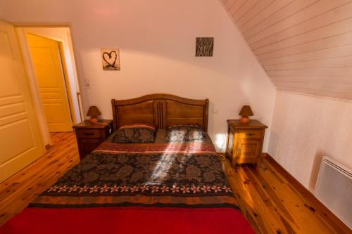 ein Schlafzimmer mit einem Bett und zwei Nachttischen in der Unterkunft Village de Nasbinals Aubrac Electro Vélo in Nasbinals