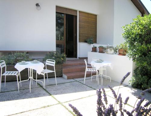 a patio with two tables and chairs in front of a house at Bed And Breakfast 22 Garibaldi Home in Riccione
