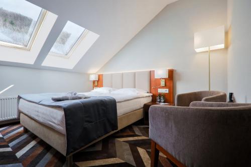 a hotel room with a bed and two chairs at Hotel Belweder in Ustroń