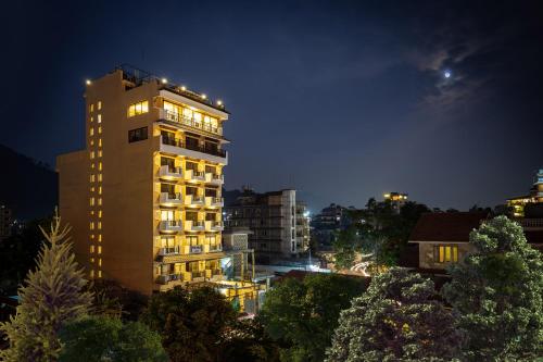 a tall building with lights on it at night at Hotel Mala Pokhara in Pokhara