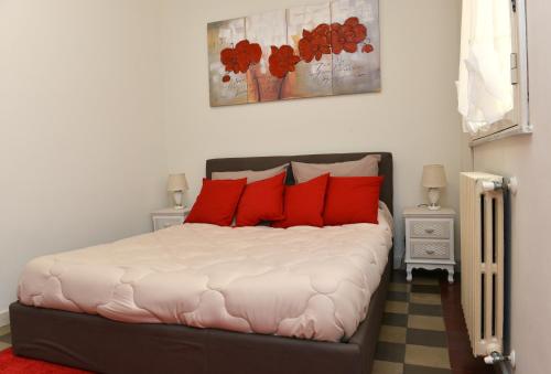 a bedroom with a large bed with red pillows at Niria Home in Catania