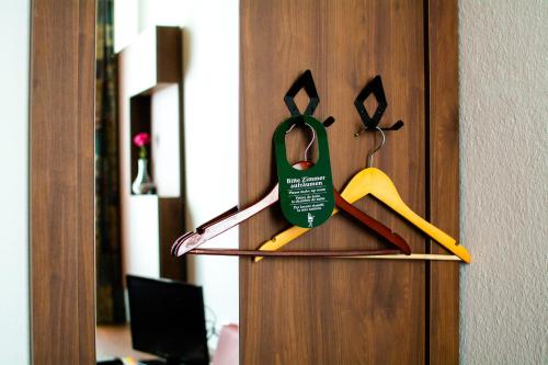 a door with a pair of scissors and a green tag at Hotel Fränkischer Hof in Kitzingen