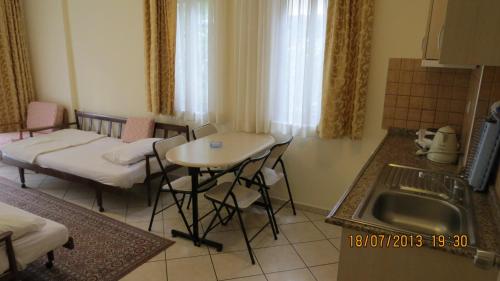 a kitchen with a table and a sink and a table and chairs at Arya Otel in Marmaris