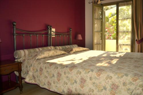 a bedroom with a large bed with red walls at Zephyros Hotel in Kamari
