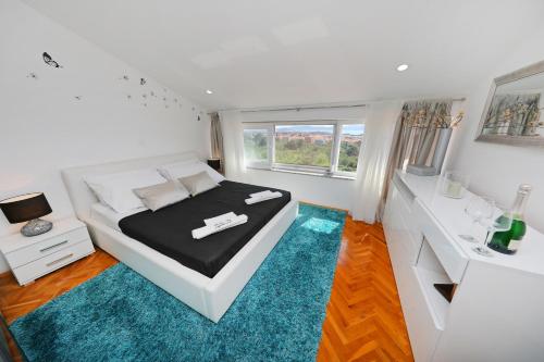 - une chambre blanche avec un lit et un tapis bleu dans l'établissement Magic Blue Sky Apartment, à Zadar