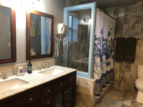 La salle de bains est pourvue de 2 lavabos, d'une douche et de toilettes. dans l'établissement Ramsey Canyon B&B, à Nicksville