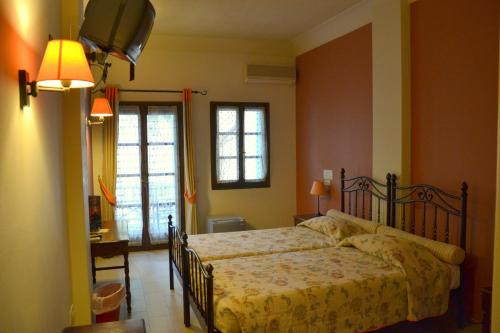 a bedroom with a bed and a desk and a window at Zephyros Hotel in Kamari