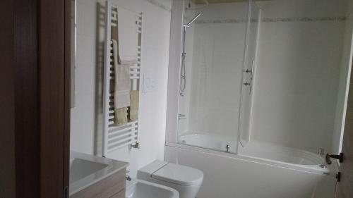 a bathroom with a tub and a toilet and a sink at Agriturismo Cascina Poscallone in Abbiategrasso