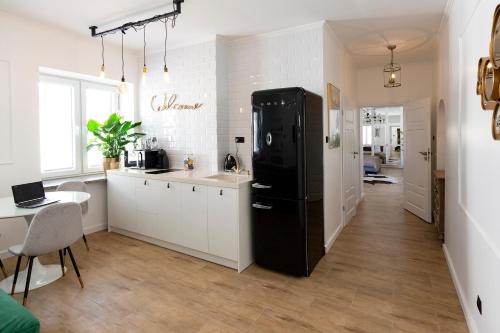 eine Küche mit einem schwarzen Kühlschrank und einem Tisch in der Unterkunft Amazing Apartment in the Heart of City Center in Lublin